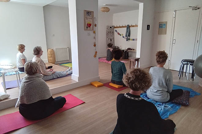 Cours de Feldenkrais dans la salle où se déroulent les cours et ateliers de Feldenkrais au cabinet kinés Guillaume Humetz à Gap, la salle est claire et agréable dans les teintes de blanc, avec des touches de corail et bleu, avec un parquet au sol