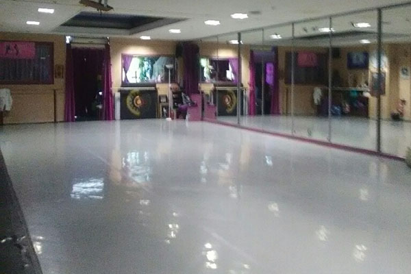 Photo de la salle DK Danse, grande salle claire avec de grands miroirs aux murs, équipée pour la danse