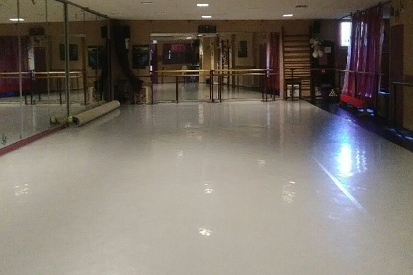 Photo de la salle DK Danse, grande salle claire avec de grands miroirs aux murs, équipée pour la danse avec des barres pour la danse classique