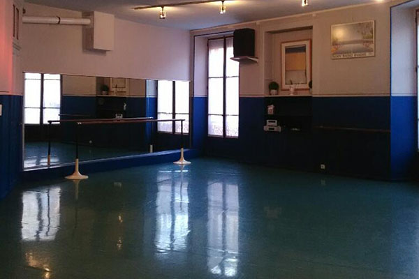 Photo de la salle Studio 31, vue de l'entrée de la salle - salle lumineuse aux couleurs bleue et blanche, haut de plafond, avec les équipements pour la danse (barres, miroirs) 