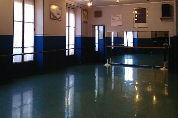 Photo de la salle Studio 31 - salle lumineuse aux couleurs bleue et blanche, haut de plafond, avec les équipements pour la danse (barres, miroirs) 