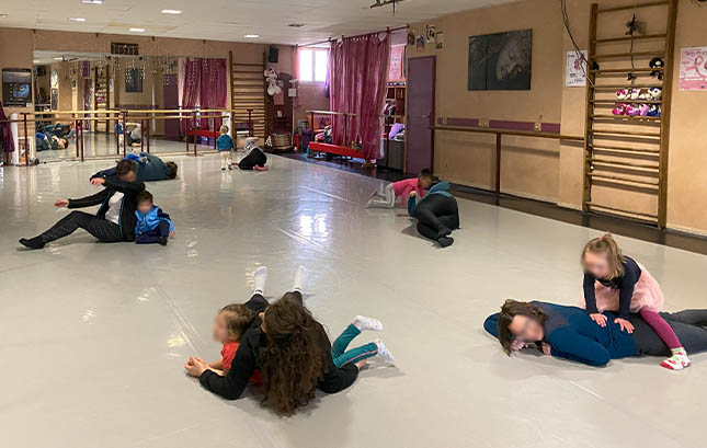 Atelier dansant parent-enfant, groupe 2-4 ans, à Gap - photo : Virginie Perret-Reiso Les parents et leur enfant évoluent dans diverses positions, au sol.
