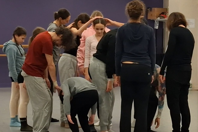 Hélixes Cie Pierre de Lune Groupe Inter-générations - répétition en vue des regards chorégraphiques 2026 - les danseurs sont rassemblés en groupe et se baissent en courbant le dos et en pliant les jambes