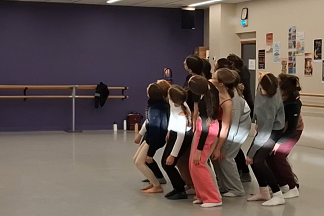 Hélixes Cie Pierre de Lune Groupe Inter-générations - répétition en vue des regards chorégraphiques 2026 - les danseurs sont rassemblés en groupe resserré et se baissent vers leur côté gauche en pliant les jambes et en regardant vers le haut